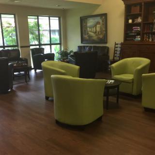 A cozy waiting area with green chairs and a warm ambiance.