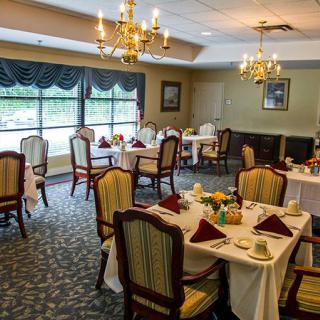 An elegant dining room with set tables and chandeliers.