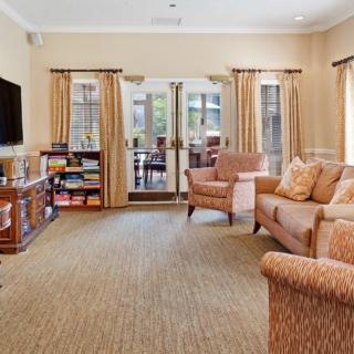 A cozy living room with comfortable seating, a television, and a bookshelf.