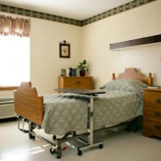 A clean and organized hospital room with a bed and medical equipment.
