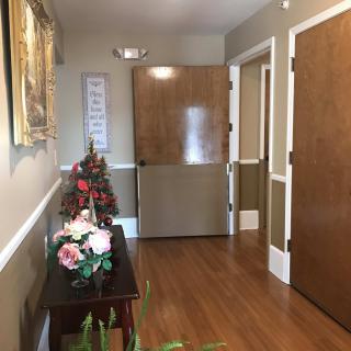 A hallway with decorative flowers and a wooden floor.