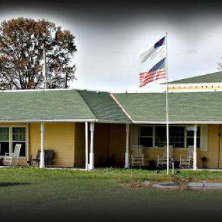 A charming building with a green roof and flags waving in front.