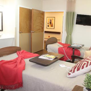 A cozy hospital room featuring two patient beds, designed for comfort and care.