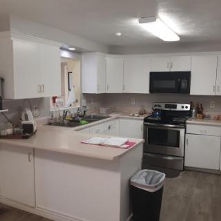 A modern and stylish kitchen featuring white cabinets and stainless steel appliances.