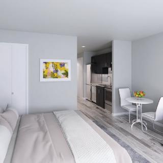 A modern, minimalist apartment featuring a cozy bedroom with a small kitchenette and dining area.