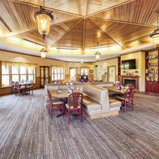 A cozy restaurant interior with a wooden ceiling and arranged dining tables.