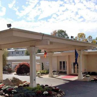 Exterior view of a building with a covered entrance and landscaping.
