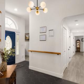 A modern and inviting hallway with stylish lighting and decor, leading to various rooms in the home.