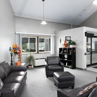 A modern and inviting lounge area featuring black leather furniture and decorative elements.
