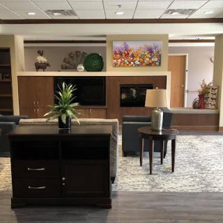 A modern lobby featuring stylish furniture, decorative plants, and artwork.