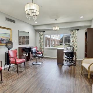 A stylish salon interior with hairdressing stations, chairs, and elegant lighting.