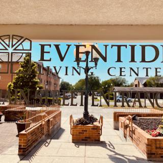 A view of the Eventide Living Center showcasing its welcoming entrance and outdoor area on a bright sunny day.