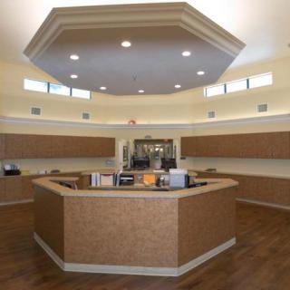 A modern reception area with a central desk and overhead lighting.