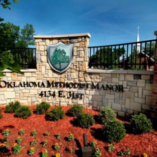 Entrance sign for Oklahoma Methodist Manor surrounded by landscaped garden.