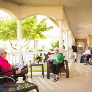 Residents enjoying a peaceful afternoon on the patio of a nursing home.