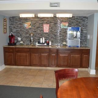 A modern kitchen with wooden cabinets, a countertop, and beverage appliances.