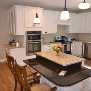 A modern kitchen with a central island and white cabinetry.