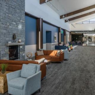 A modern lobby with comfortable seating and a fireplace.