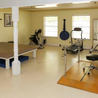 A gym interior featuring various exercise equipment and workout areas.