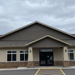 A modern one-story building with a central entrance and large windows.