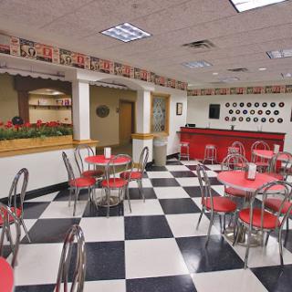 A cozy dining area featuring red tables and a black-and-white checkered floor, perfect for casual meals.