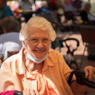 A joyful elderly woman enjoying her time outdoors.