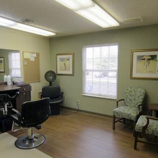 A cozy barber shop interior with chairs and artwork on the walls.