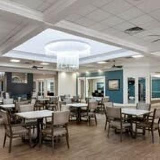 A well-lit dining area with neatly arranged tables and chairs, featuring a modern interior design.