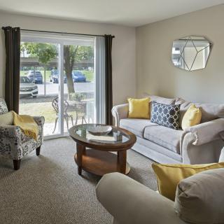 A cozy living room with stylish furnishings and a large window view.