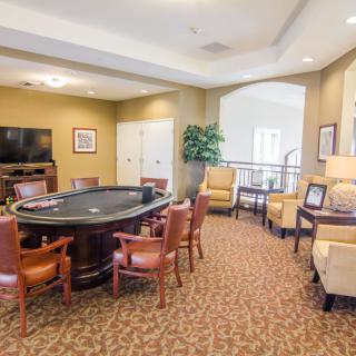 A cozy entertainment room with a poker table, comfortable seating, and a television.