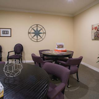 A small meeting room with a round conference table and chairs, decorated with wall art.
