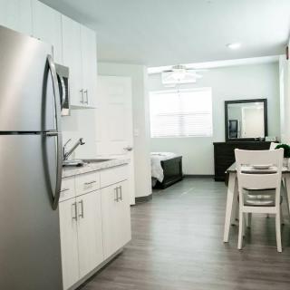 A modern, minimalist kitchen interior in an apartment setting.