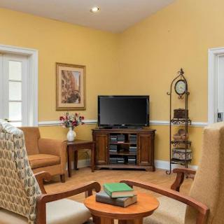 A cozy living room featuring warm yellow walls and inviting seating arrangements.