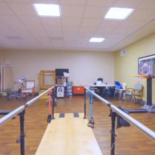 A physical therapy room equipped with parallel bars for rehabilitation exercises.