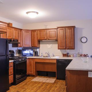 A modern kitchen with wooden cabinets and black appliances.