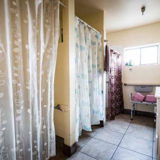 A clean bathroom with shower curtains, a sink, and natural light from a window.