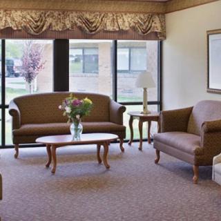 A cozy living room with comfortable sofas and a coffee table in front of large windows.