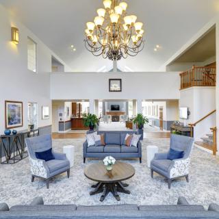 Spacious living room with elegant chandelier and modern seating arrangement.