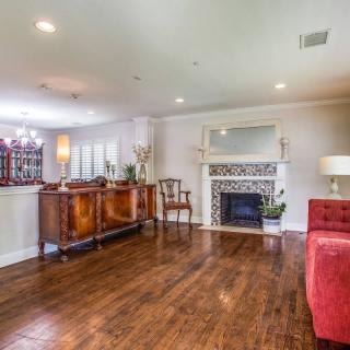 A cozy living room with elegant wood flooring, featuring a fireplace and stylish furnishings.