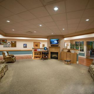 A spacious living room with comfortable seating, a television, and a cozy fireplace.