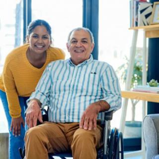 A cheerful moment between two people, with one seated in a wheelchair.