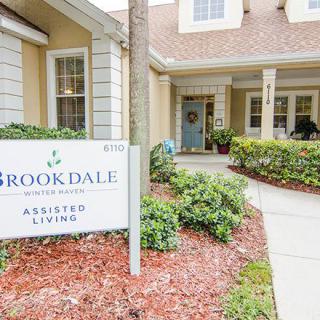 Entrance to an assisted living facility with signage and landscaping.
