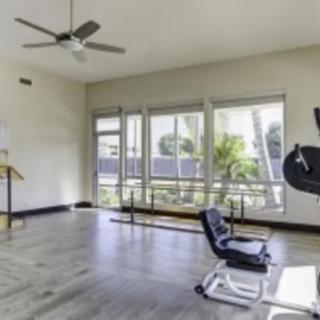 A spacious gym with exercise equipment and large windows.