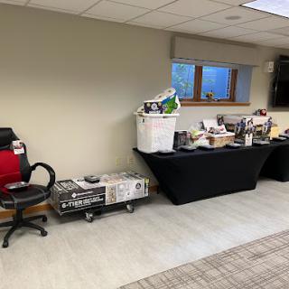 An organized workspace featuring chairs and a table with various items displayed.