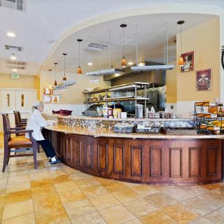 A cozy restaurant interior with a curved counter and seating area.