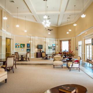 A spacious and well-decorated lobby with elegant seating and chandeliers.