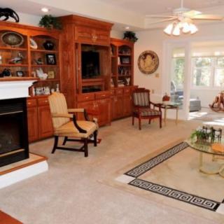 A cozy living room featuring a fireplace, wooden bookshelves, and comfortable seating.