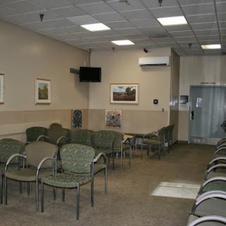 A waiting room in a medical facility, featuring several chairs and a calm, minimalist design.