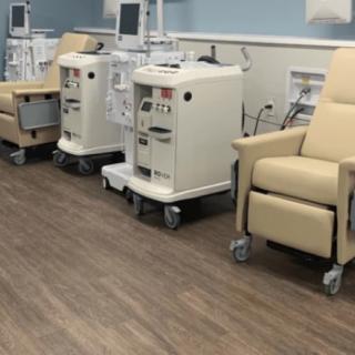 A clinical setting with dialysis machines and chairs for patient treatment.