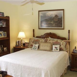 A cozy bedroom with a large bed, wooden furniture, and warm lighting.